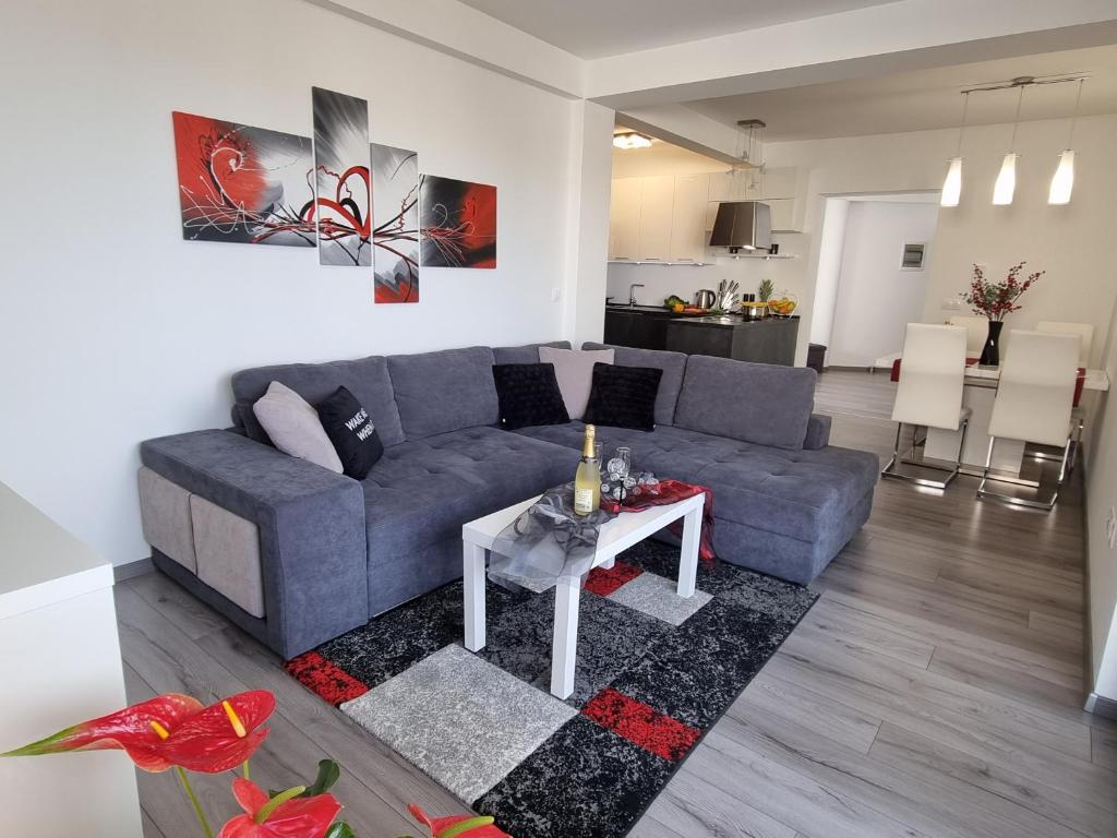 uma sala de estar com um sofá azul e uma mesa em Sea View Medulin Apartment - Orijeta em Medulin