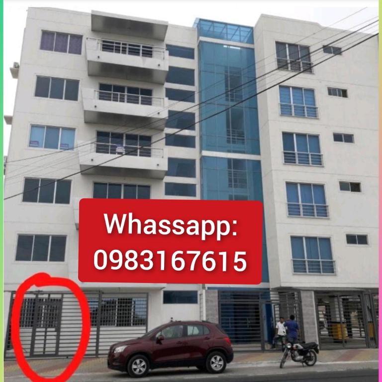 a red sign in front of a building at Habitacion Vacacional Camboriu in Salinas