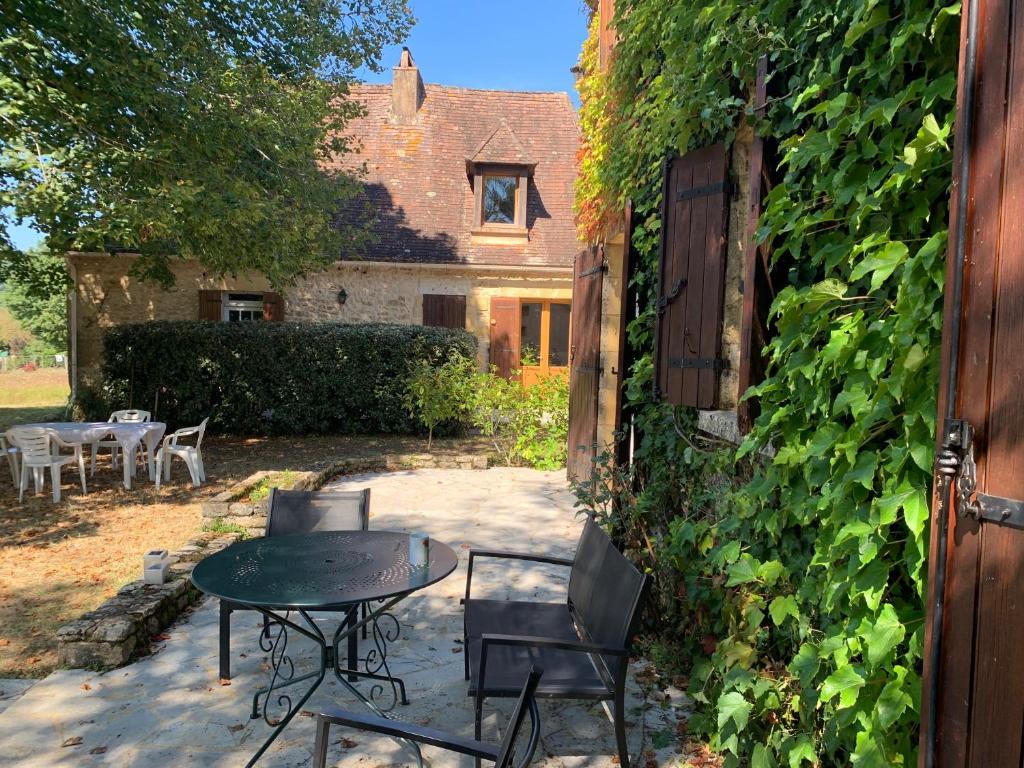 a patio with a table and chairs in front of a building at Villas de la Plaine in Calès