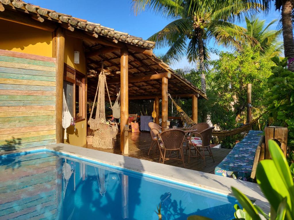 a house with a patio and a swimming pool at Bangalo Outeiro das Brisas in Praia do Espelho