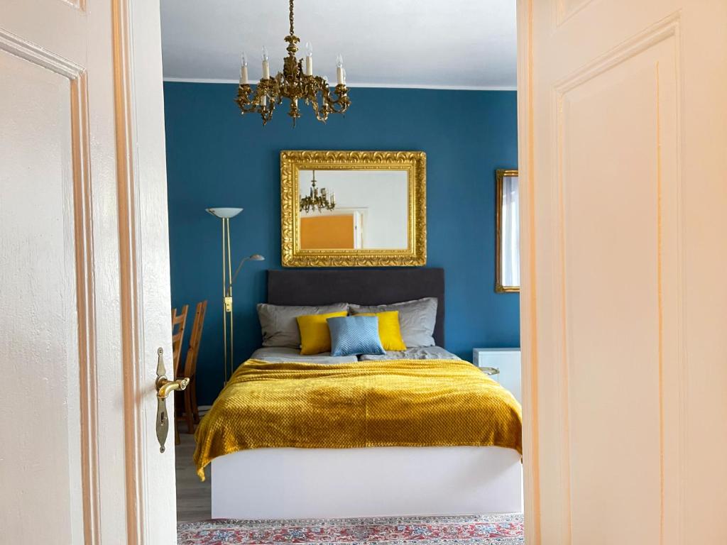 Dormitorio azul con cama y espejo en Comfy Apartments - Monte Cassino Sun en Sopot