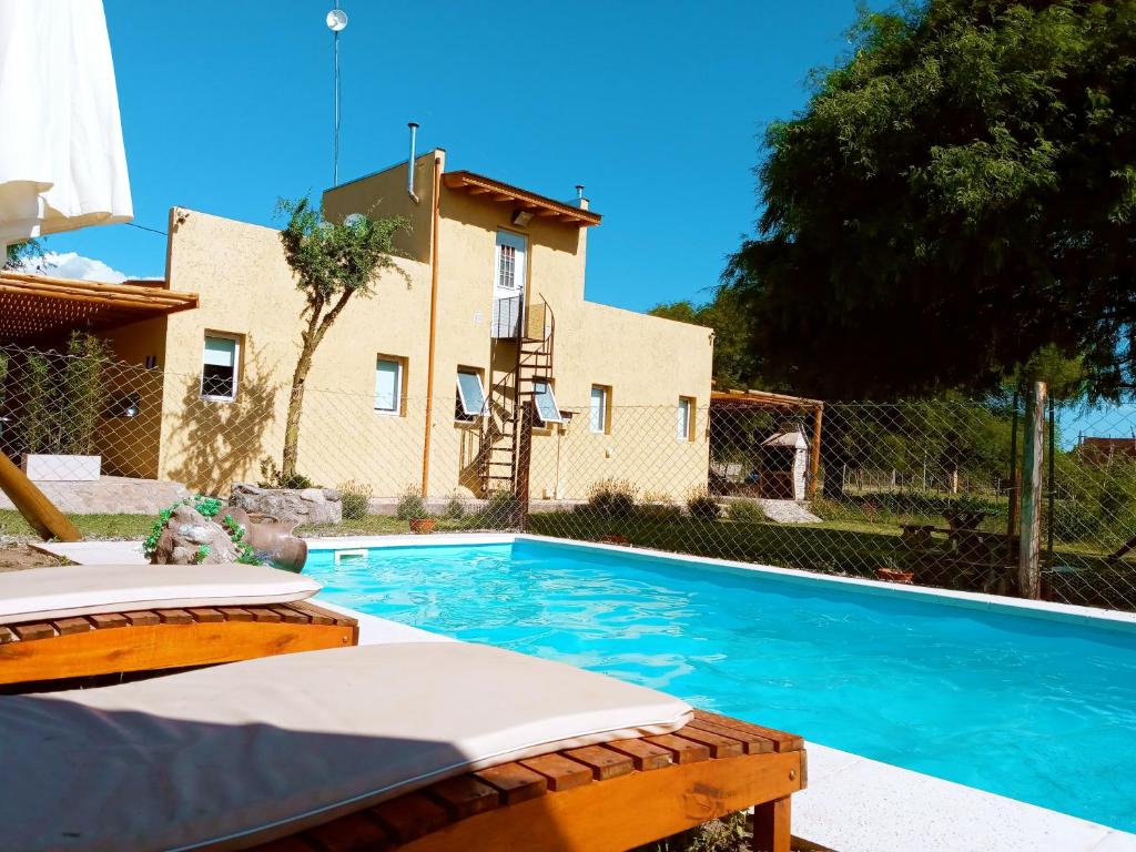 a swimming pool in front of a house at El Rincón de Alejo in Merlo