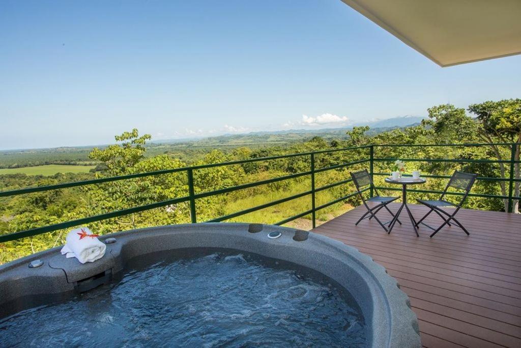 bañera de hidromasaje en una terraza con mesa y sillas en Villa Vista Hermosa - with breathtaking ocean view & WiFI, en Quepos
