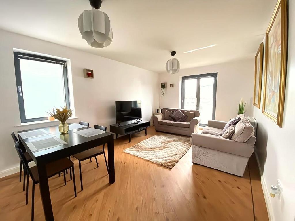 a living room with a table and a dining room at Lovely 2-Bedrooms Apartment Step to The Beach in Swansea