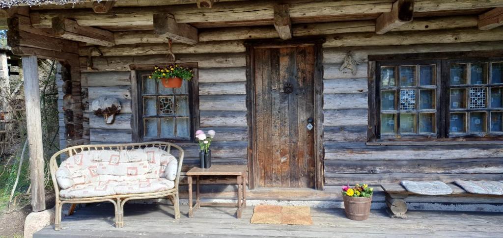 BērzciemsにあるBrīvdienu māja Branguļiの木造の小屋(椅子、ドア付)