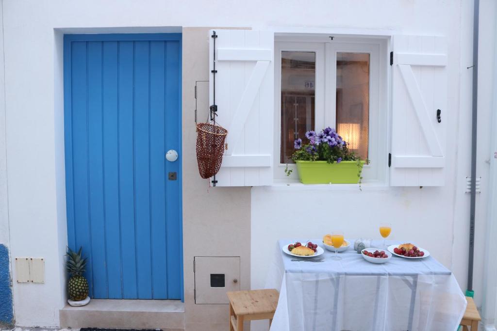 een blauwe deur en een tafel met fruit erop bij Tiny House in Nazaré