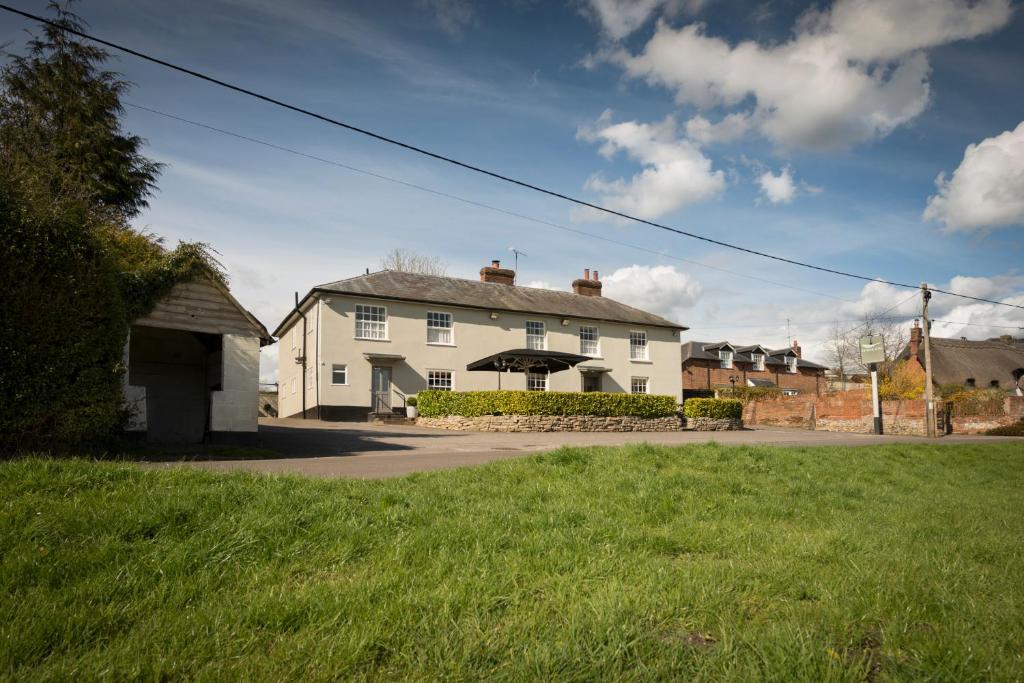 uma casa branca numa rua com relva verde em The Hawk Inn em Andover