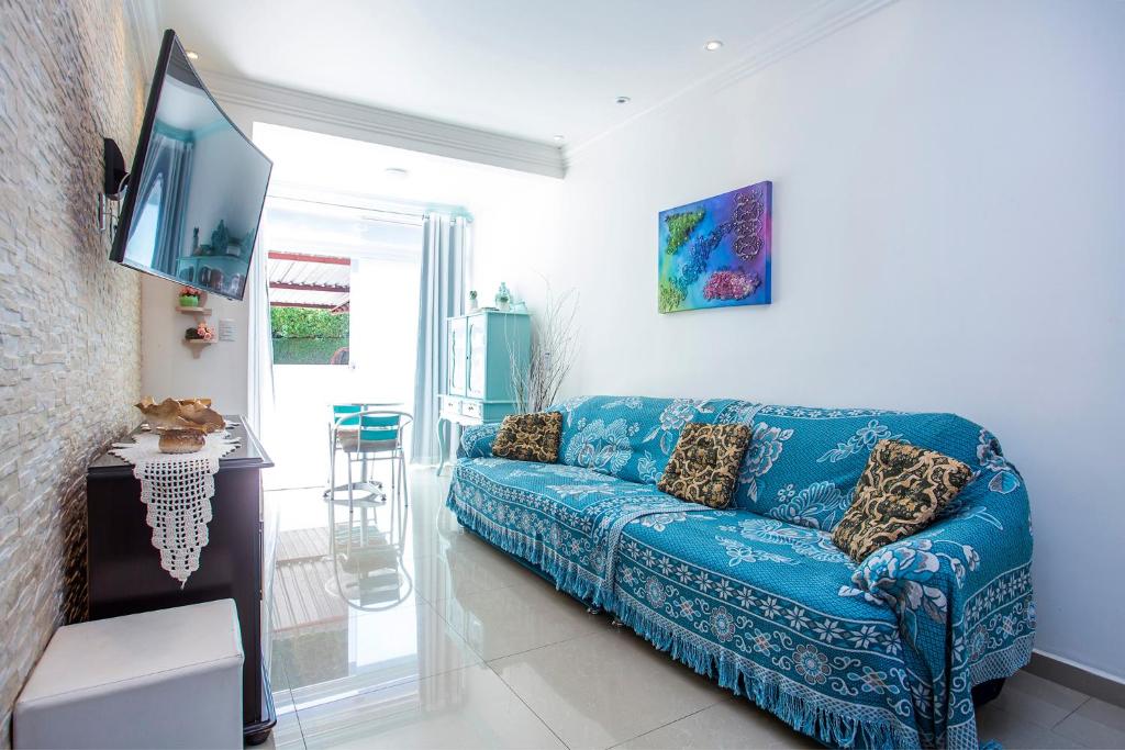 a living room with a blue couch and a tv at Apartamento Águas de Lindoia in Águas de Lindóia