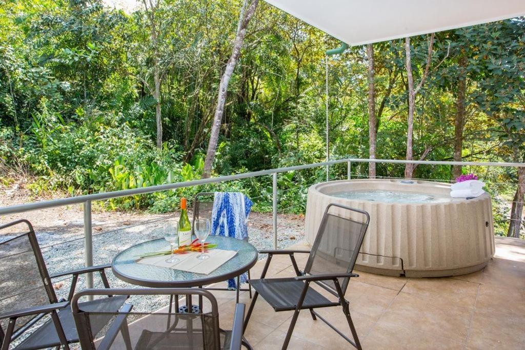 une terrasse avec une table et des chaises ainsi qu'un bain à remous dans l'établissement Villa Iguana - Great place & privacy with Jacuzzi & WiFi, à Quepos
