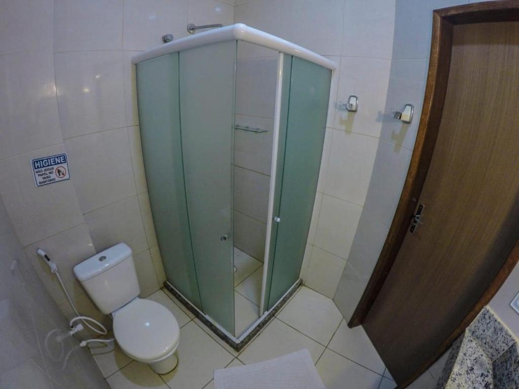y baño con ducha de cristal y aseo. en Espaço Viana, en Porto de Galinhas