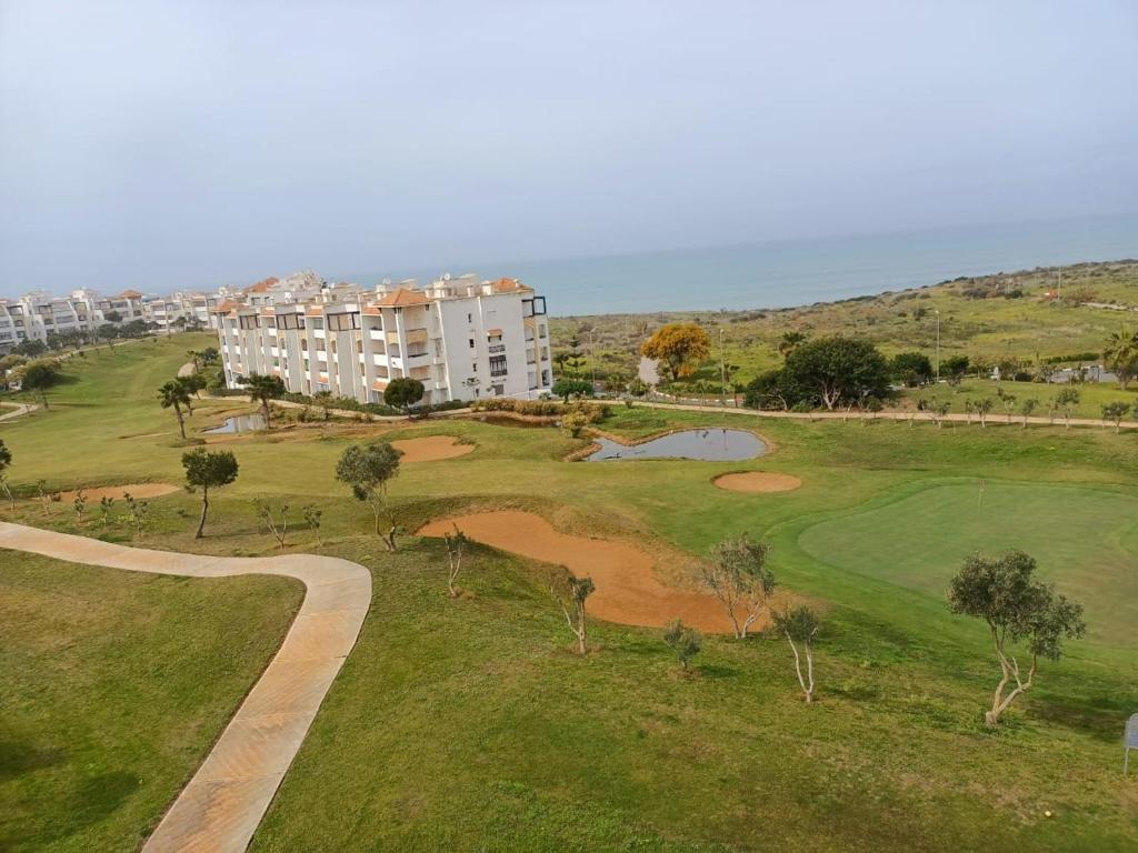 an aerial view of a golf course with a building at Marina Golf Asilah Vue mer et golf in Asilah