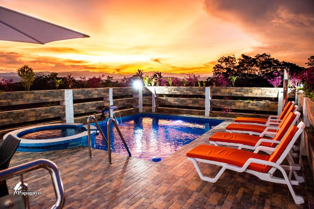 una piscina con tumbonas y una piscina en Hotel Boutique Papagayo en Tarapoto