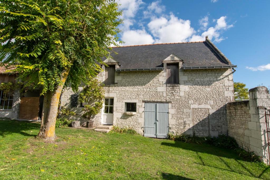 an old stone house with a tree in the yard at le Guimapé in Assay