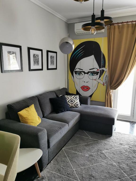 a living room with a couch with a painting of a woman at Adrianos House by the sea in Iraklitsa