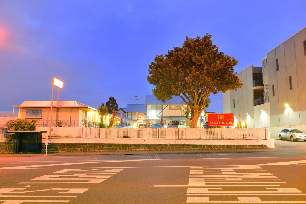 una calle vacía por la noche con un árbol y edificios en Sai Motels - Greenlane Auckland, en Auckland