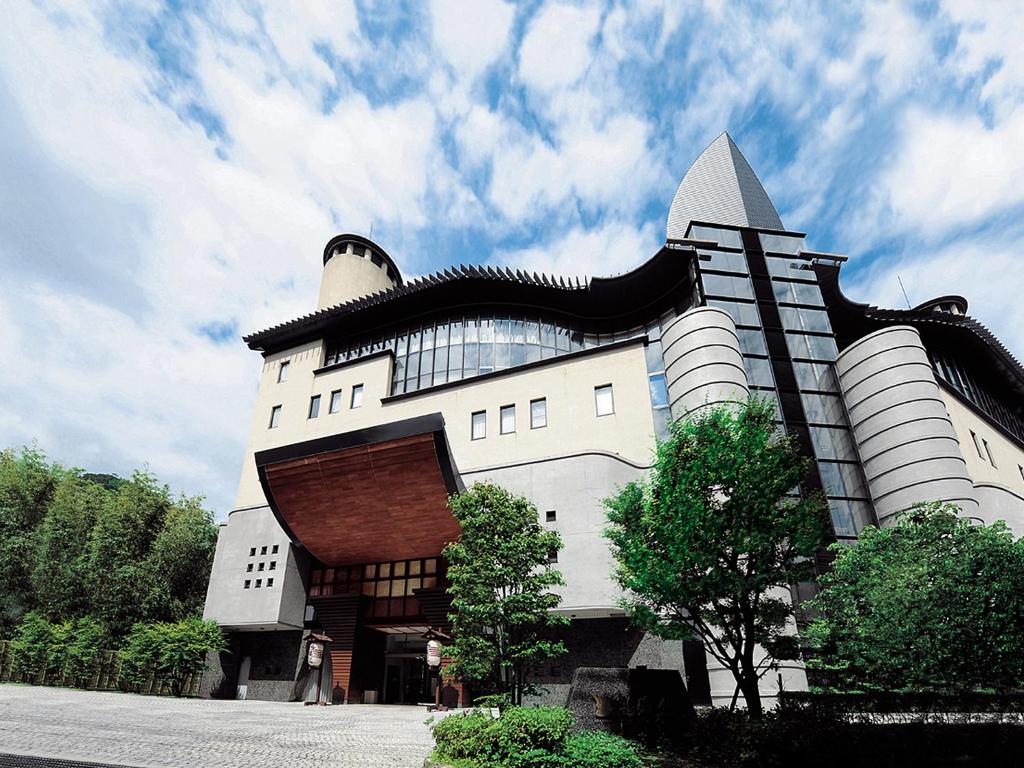 duży biały budynek z czarnym dachem w obiekcie Arima Onsen Gekkoen Korokan w mieście Kobe