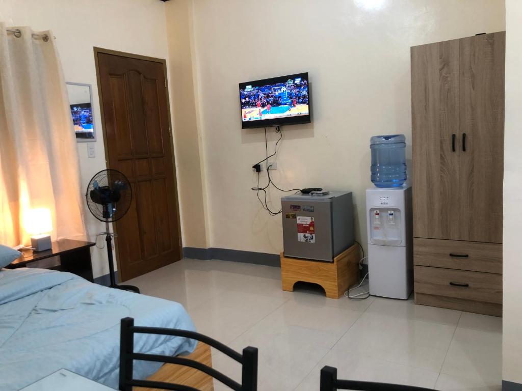 - une chambre à l'hôpital avec un lit et une télévision murale dans l'établissement Door 8 Bench Apartment, à Tacloban