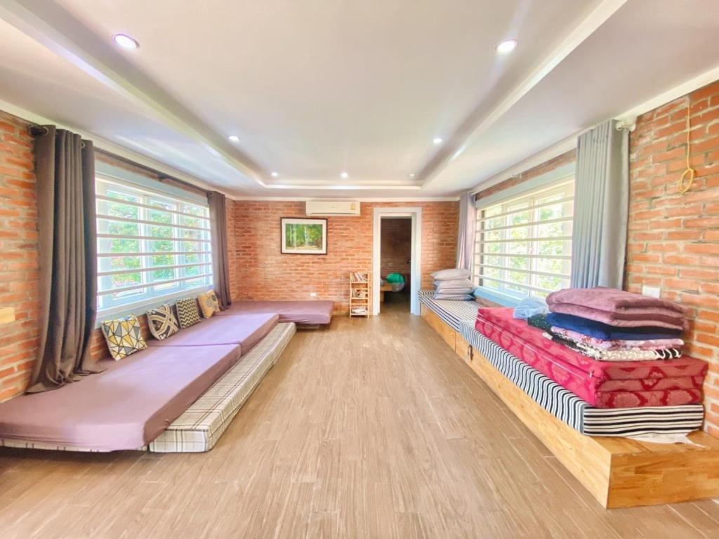 Zimmer mit Betten und Ziegelwand in der Unterkunft Brick Home Villa Sóc Sơn - Venue Travel in Hanoi