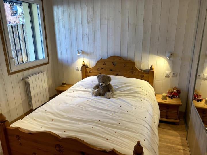 um urso de peluche sentado em cima de uma cama em Appartement Alpin em Bourg-Saint-Maurice