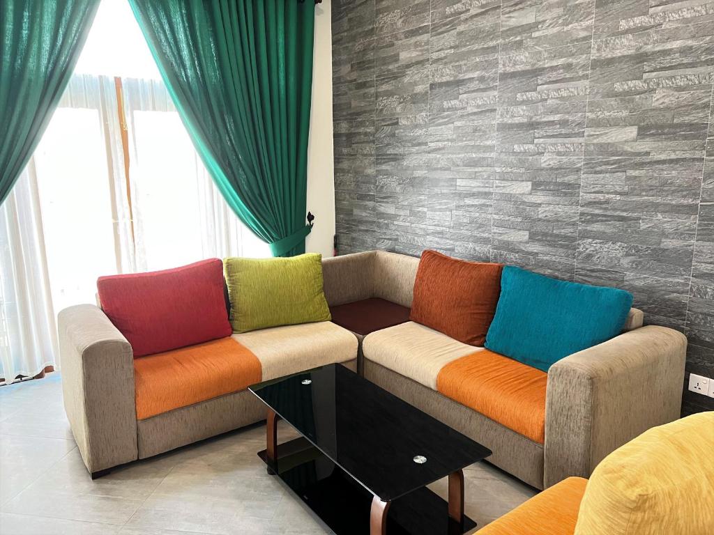 sala de estar con 2 sofás y almohadas coloridas en Hansons Homestay, en Kandy