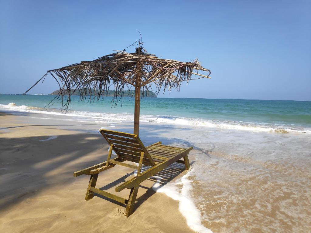 a chair sitting on the beach with an umbrella at Oliver`s Laguna ECO Lodge Hotel in Ngapali