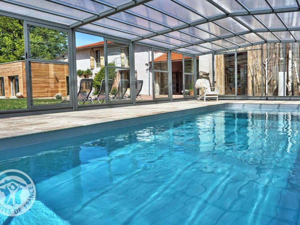 ein Pool mit einer Pergola und ein Haus in der Unterkunft Gîte Saint-Germain-Lespinasse, 7 pièces, 14 personnes - FR-1-496-6 in Saint-Germain-Lespinasse