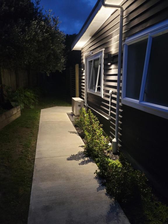 a sidewalk next to a house with a street light at Sleepout Hideaway in Rotorua