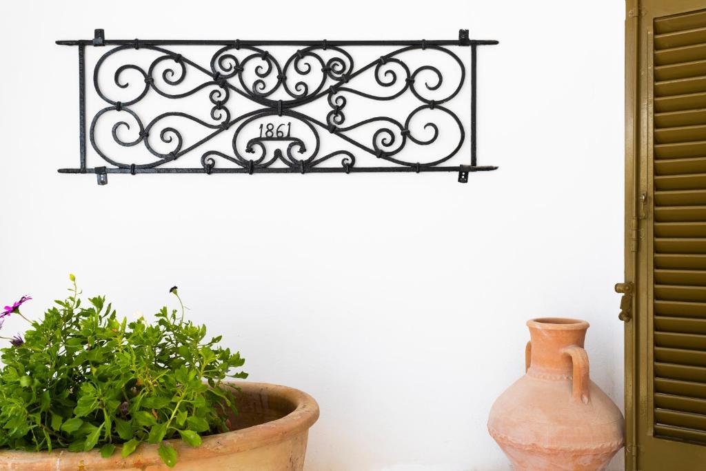 a vase and a plant sitting next to a wall at Villa Kalomira in Spetses