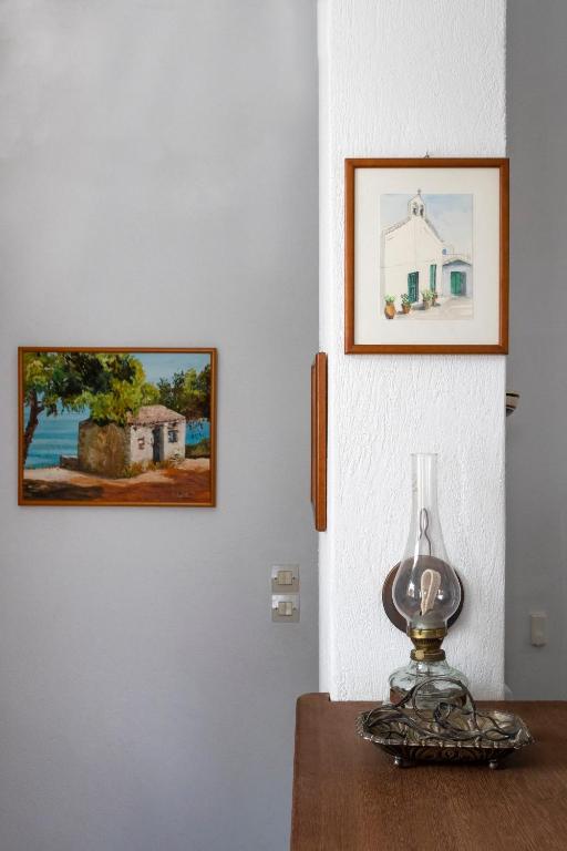a table with a lamp and a picture on the wall at Villa Kalomira in Spetses