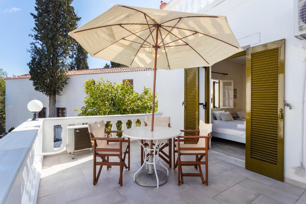 a patio with a table and chairs and an umbrella at Villa Kalomira in Spetses