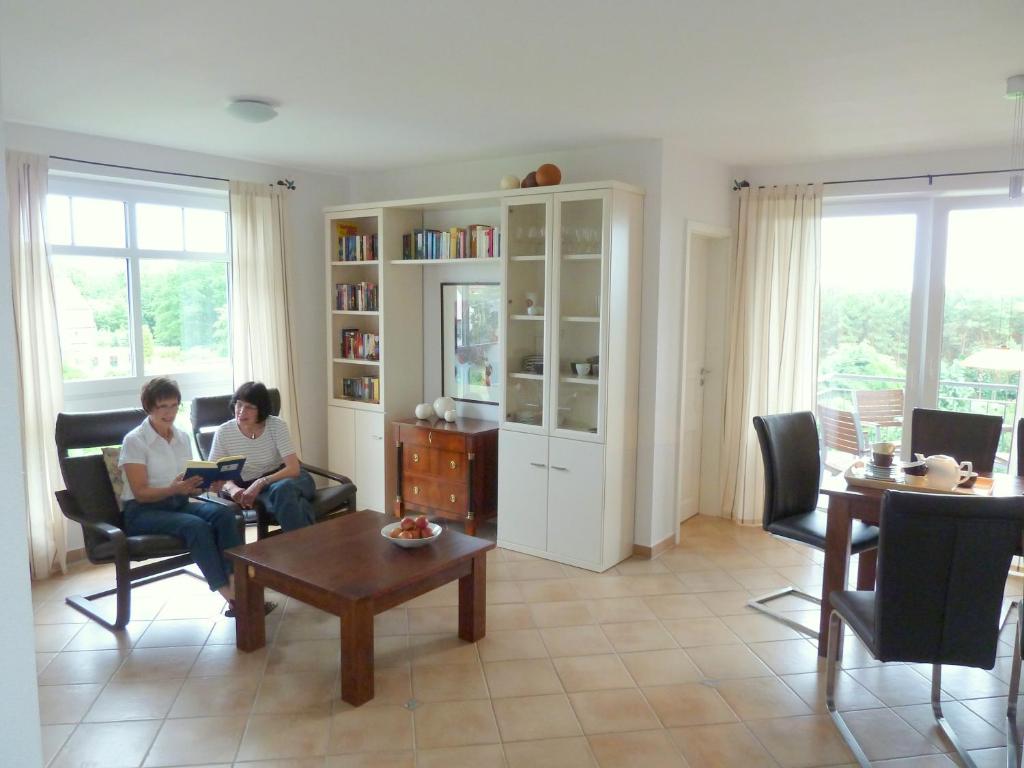 2 personnes assises dans un salon avec leurs ordinateurs portables dans l'établissement Haus Roland Wohnung 33, à Zinnowitz