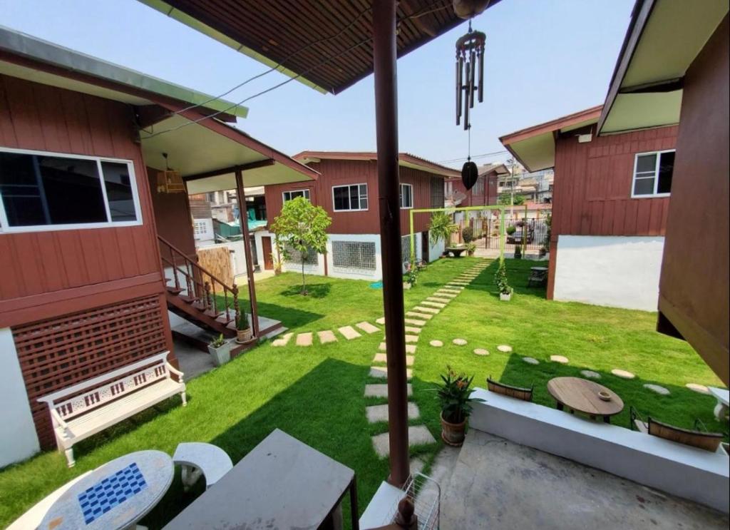 a backyard of a house with a yard with benches at Wooden hostel in Chiang Mai
