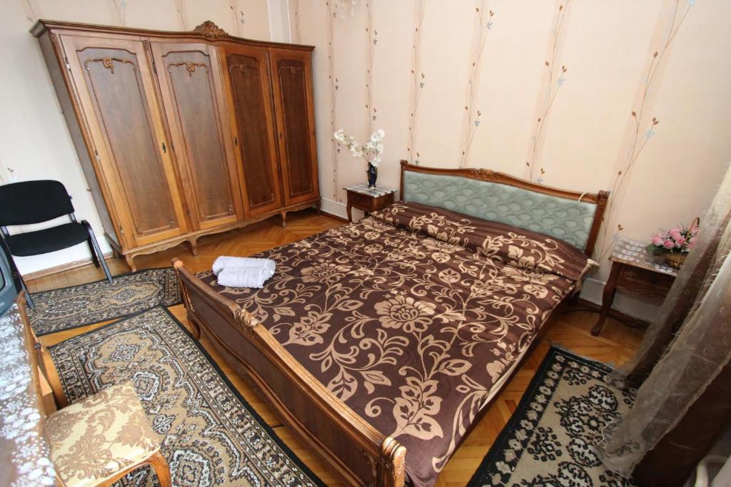 a bedroom with a bed and a wooden cabinet at Guesthouse Goliati in Kutaisi