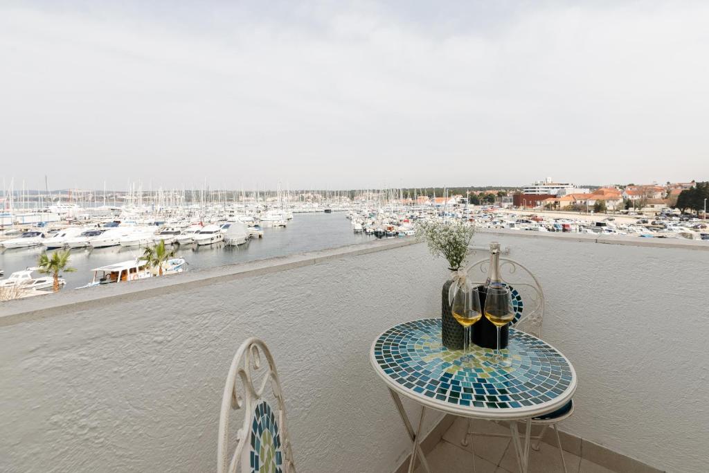 einen Tisch auf einem Balkon mit Blick auf den Yachthafen in der Unterkunft Apartman Elena in Biograd na Moru