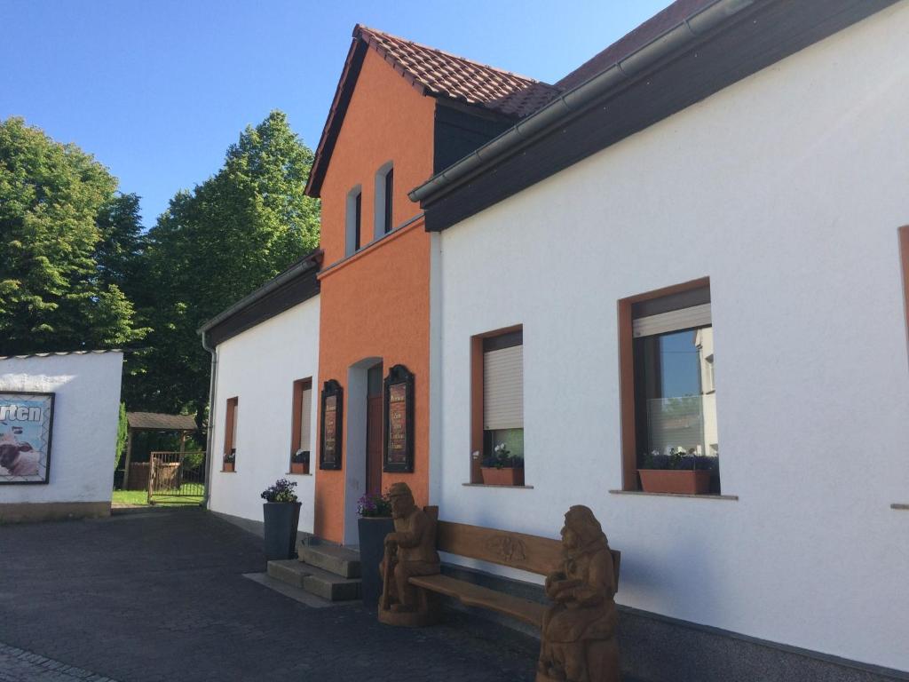um edifício branco e laranja com janelas em Pension Zum alten Gasthaus Hänsel em Krauschwitz