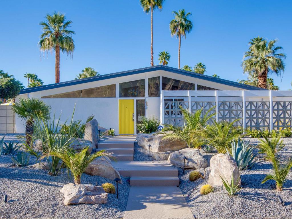 een huis met een gele deur en palmbomen bij La Joya Moderna in Palm Springs