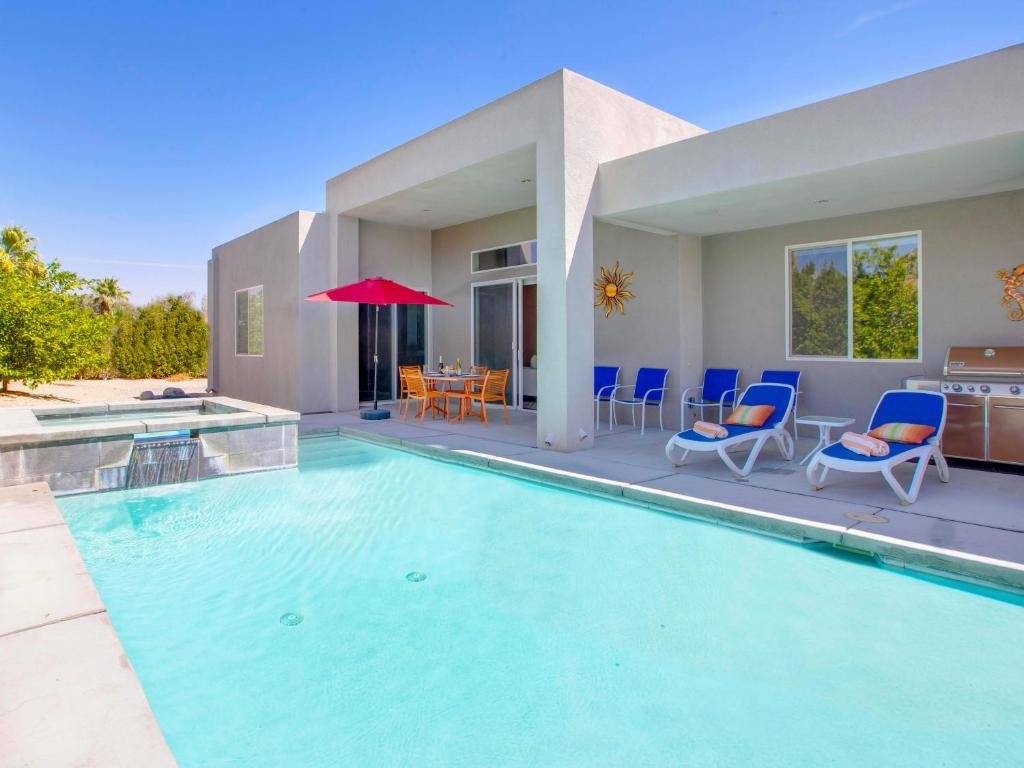 una piscina con sillas y una casa en Sun Haven Escape, en Palm Springs