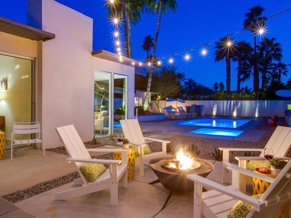 eine Terrasse mit Stühlen und eine Feuerstelle in der Nacht in der Unterkunft The Arrow in Palm Springs