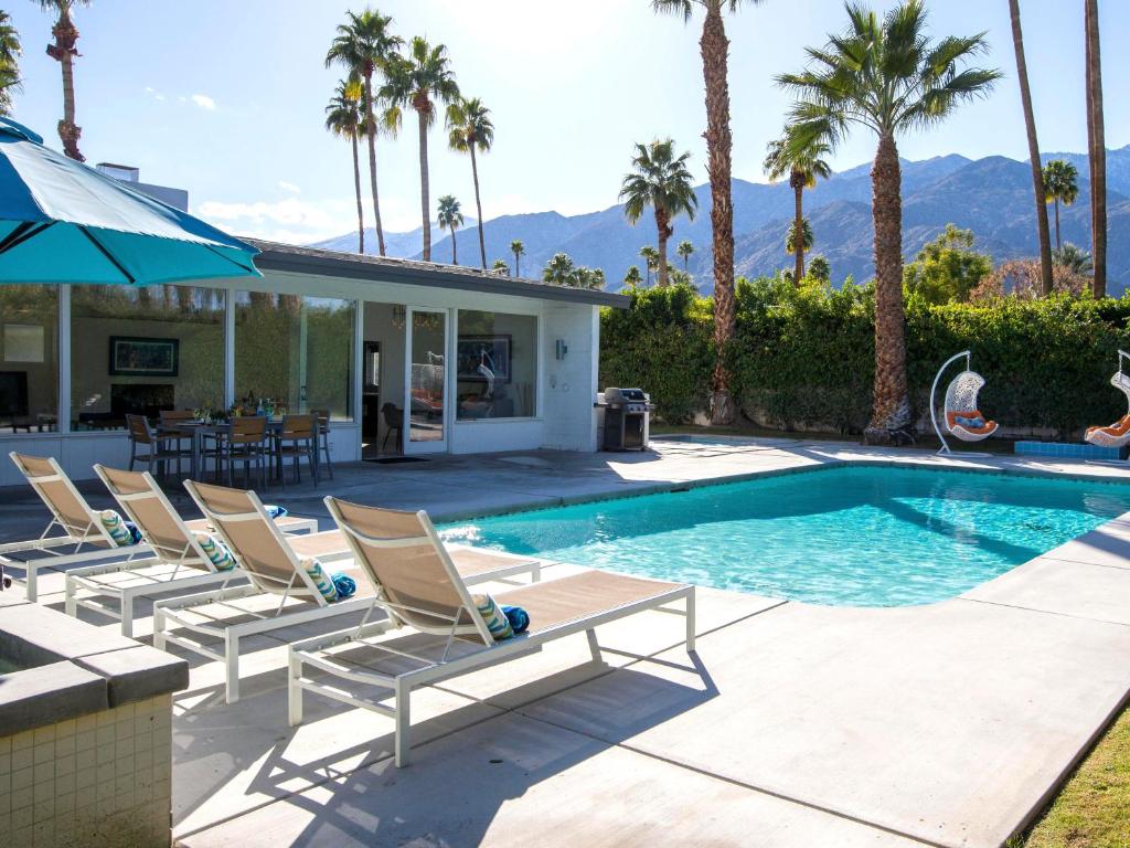 uma piscina com espreguiçadeiras ao lado de uma casa em Shag Lover em Palm Springs