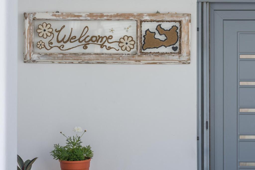un cartel de bienvenida sobre una puerta en una habitación en Balliu Apartment en Triovasálos