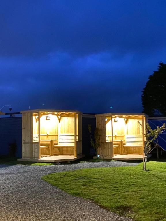 a modular house with lights in a yard at night at Elysian Fields B&B in Helston