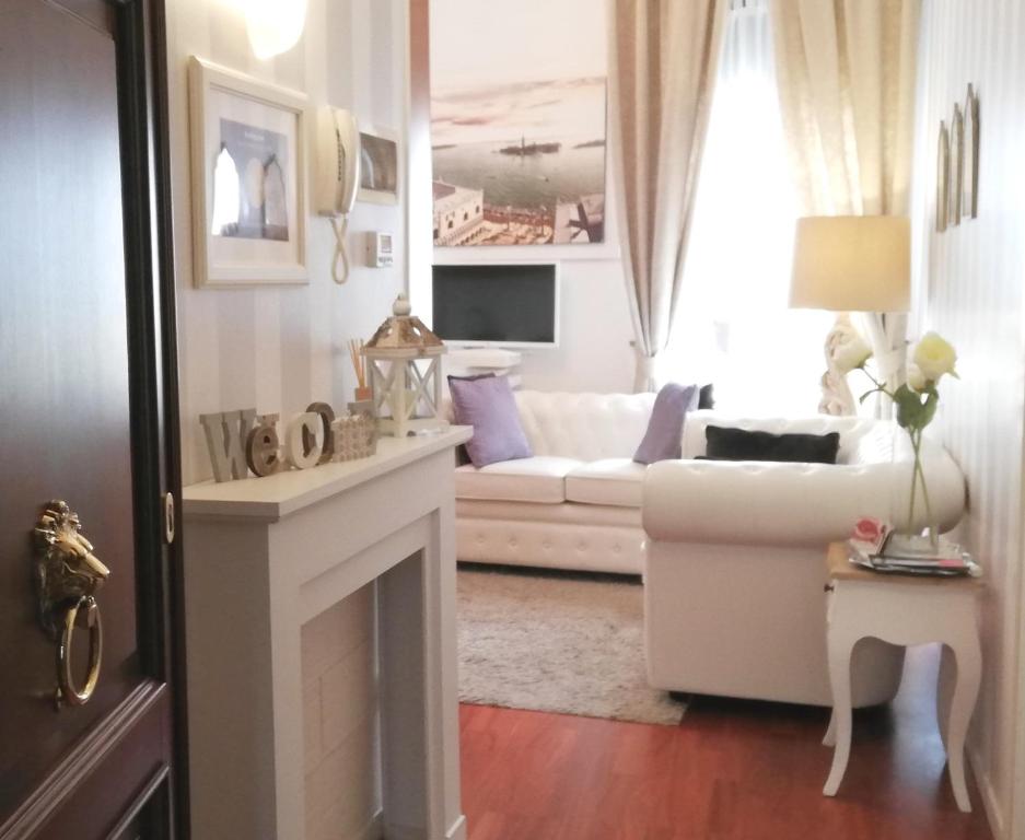 ein Wohnzimmer mit einer weißen Couch und einem Kamin in der Unterkunft San Luca Apartment in Venedig