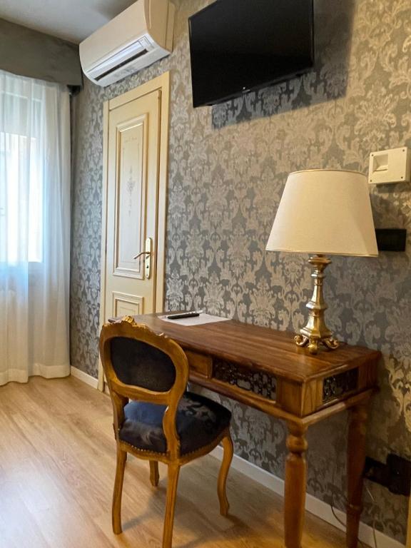 a desk with a lamp and a chair in a room at Hotel Apostoli Garden in Venice