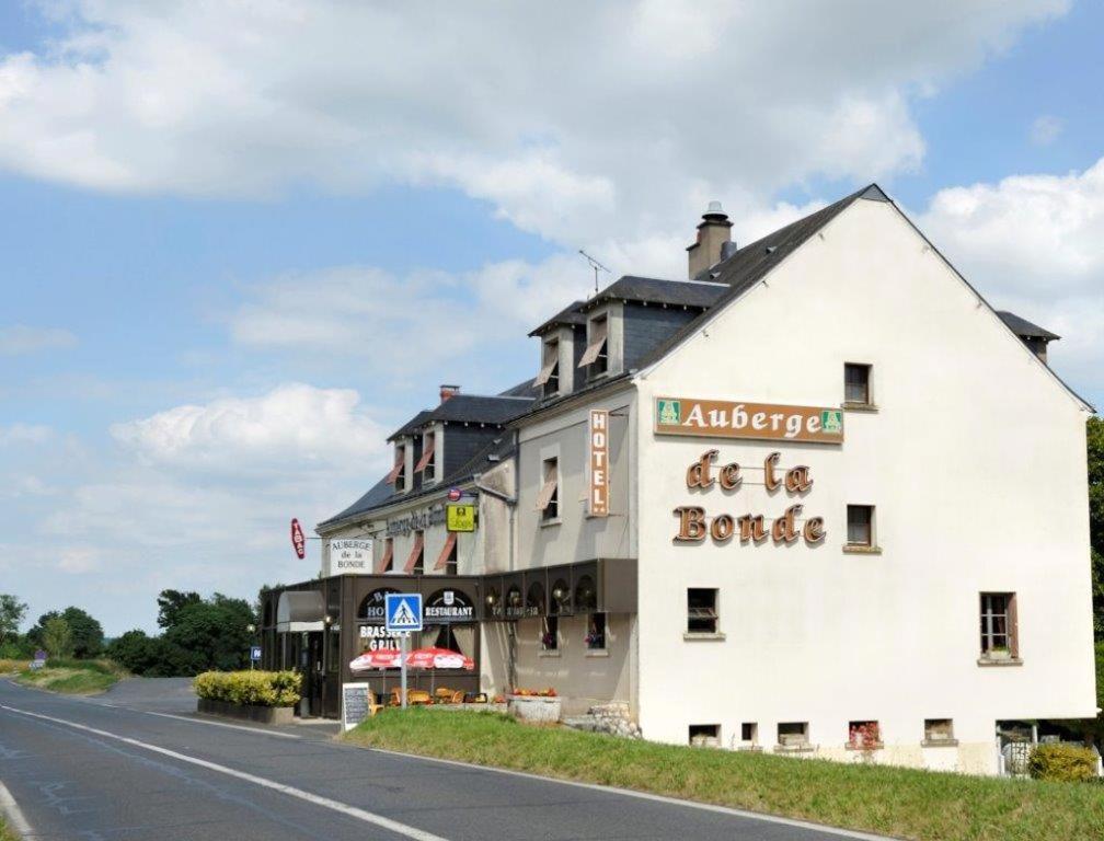 un grand bâtiment blanc sur le côté d'une route dans l'établissement Logis Hôtel Auberge de la Bonde, à Langeais