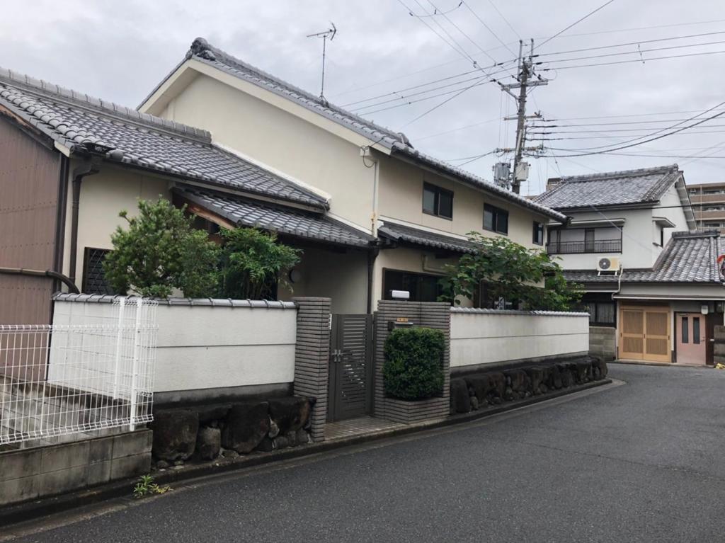 a house with white fences on the side of a street at 仔鹿 kojika in Nara