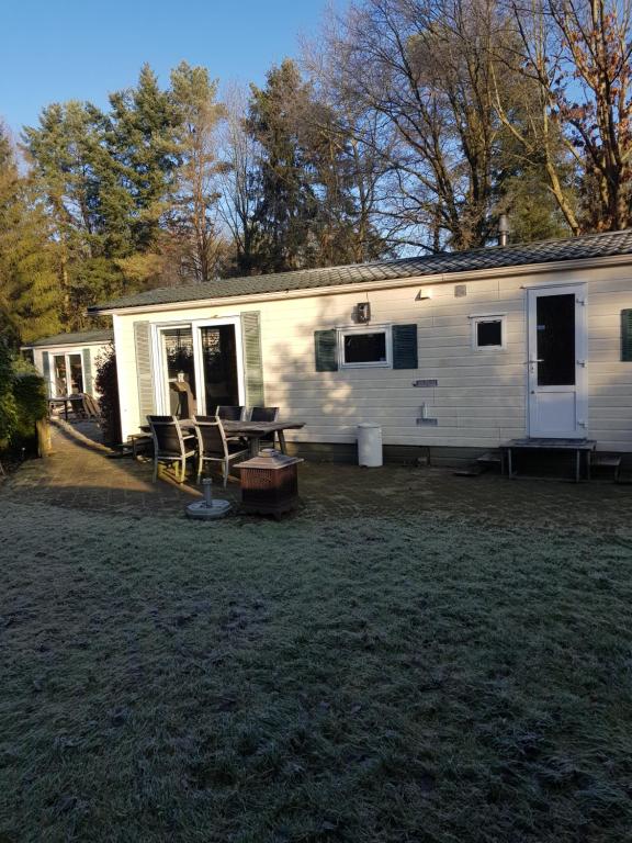 a white house with a picnic table in front of it at Chalet 4-5 Pers in Epe F16 Van alle gemakken voorzien Max aantal volwassenen is 4 in Epe