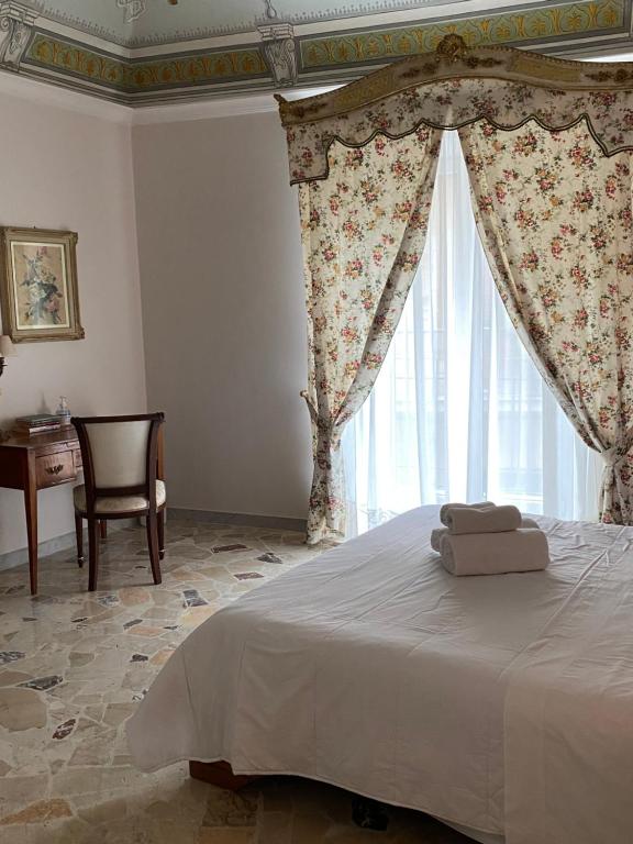 - une chambre avec un lit, une fenêtre et une chaise dans l'établissement Terebinto, à Bronte