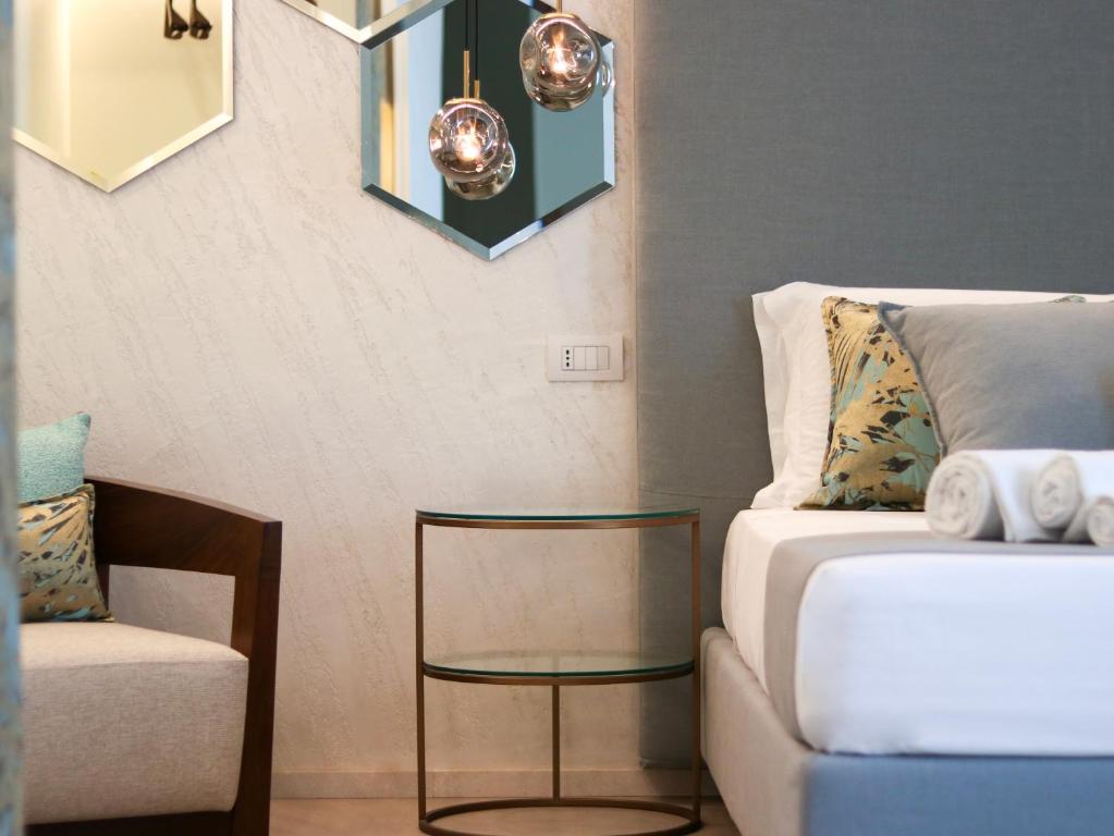 a bedroom with a bed and a chair and a mirror at Double A Luxury Room in Olbia