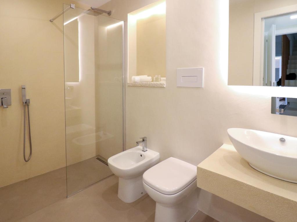 a bathroom with a toilet and a sink and a shower at Double A Luxury Room in Olbia