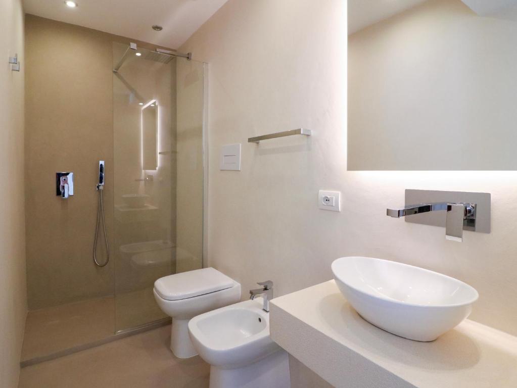 a bathroom with a toilet and a sink and a shower at Double A Luxury Room in Olbia